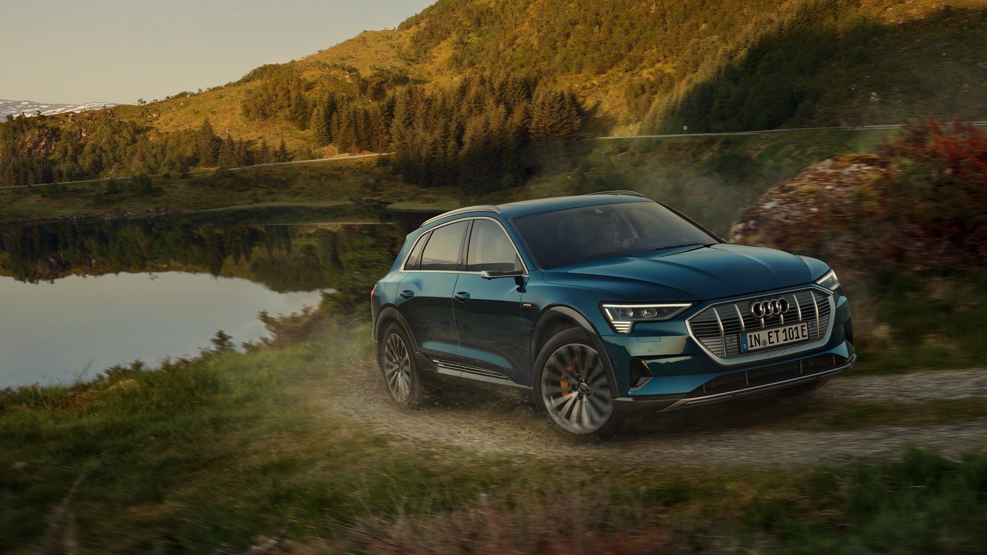 Audi e-tron fährt auf einer Landstraße nahe Gebirgen