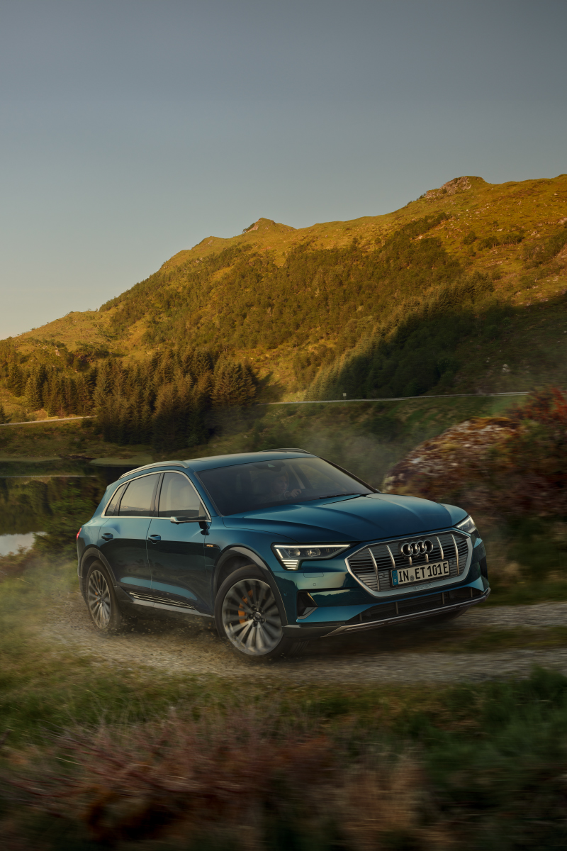 Audi e-tron fährt auf einer Landstraße nahe Gebirgen
